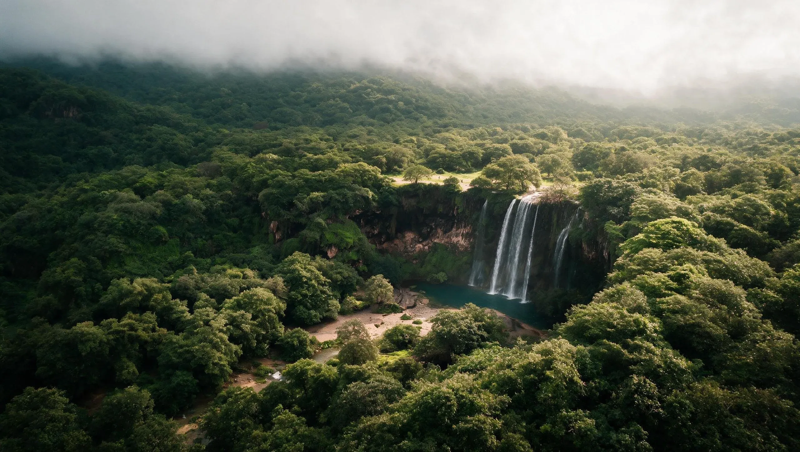 A waterfall running through the green Dhofar hills during the khareef